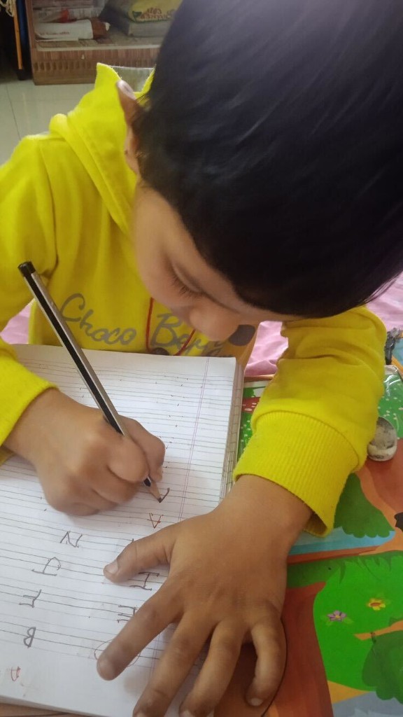 Child practising alphabet writing